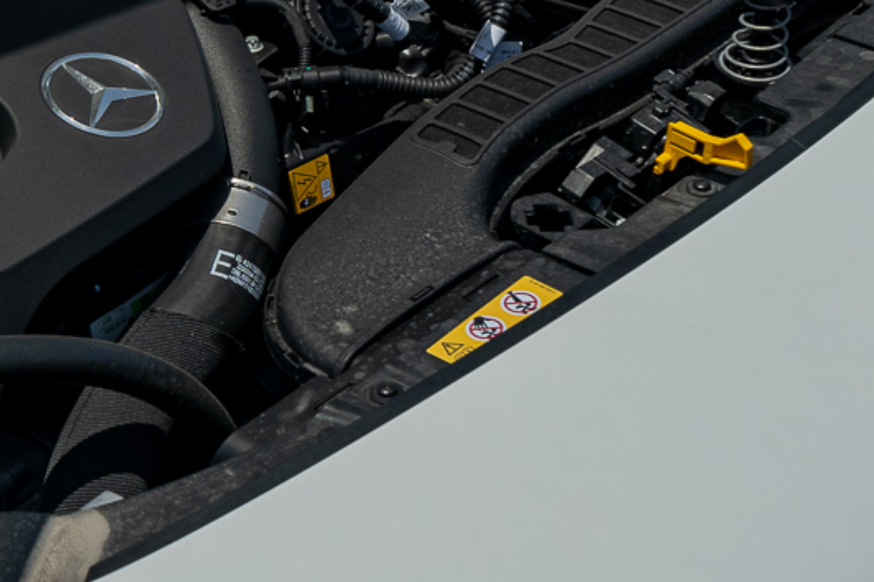 why mercedes have a tie and a hand symbol under the hood